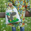 Fotografia de niño con la mochila infantil con dibujo de dinosaurios y ranita en tonos  verdes el niño lleva las bata escolar de botones de dinosaurios